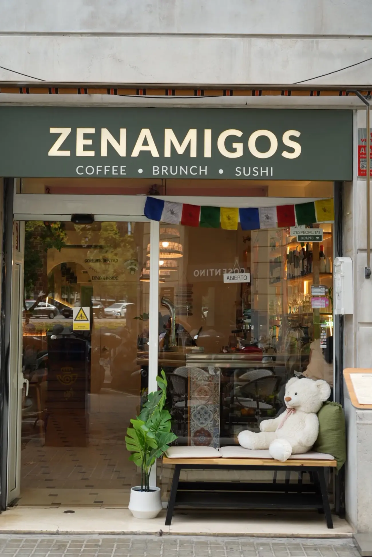 La fachada de ZENAMIGOS, con banderas de oración nepalíes sobre la puerta