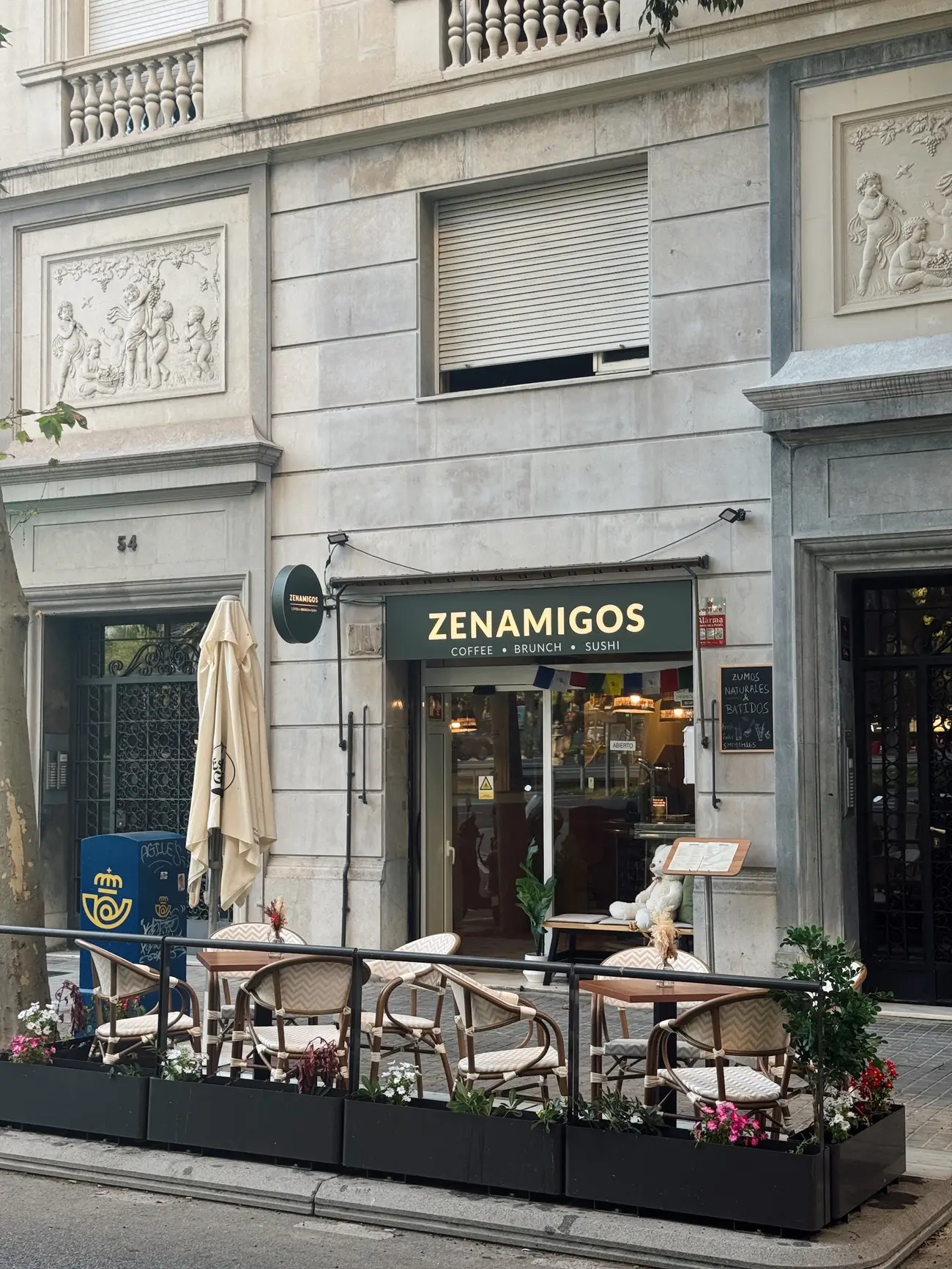 L'edifici de ZENAMIGOS al carrer de Loreto, amb el rètol verd i la terrassa