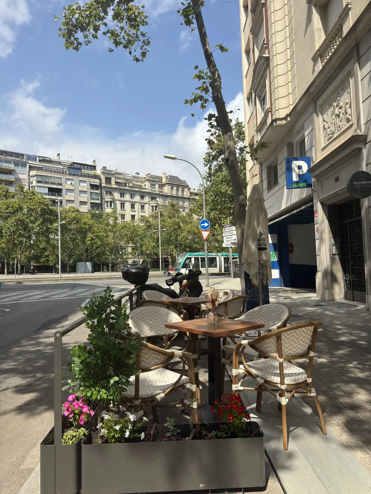 La terrassa de ZENAMIGOS a l'avinguda, amb un tramvia passant al fons